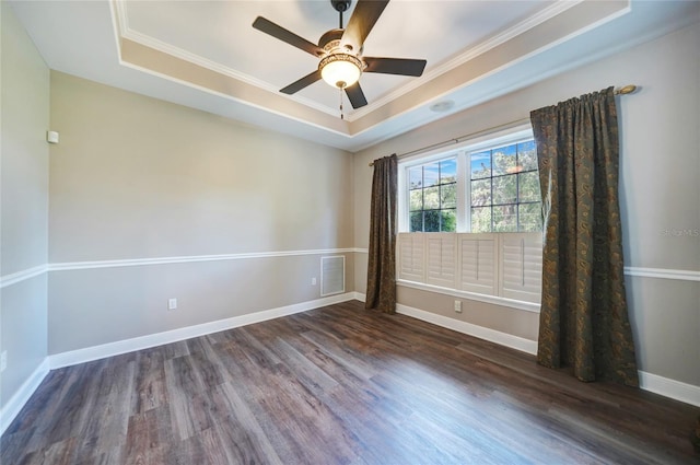 unfurnished room featuring ceiling fan, dark hardwood / wood-style floors, ornamental molding, and a tray ceiling