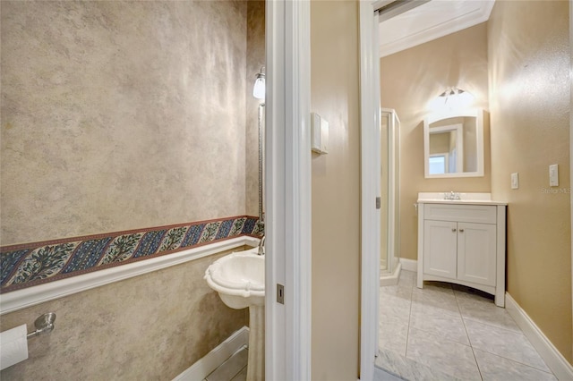 bathroom featuring baseboards, crown molding, vanity, and tile patterned floors