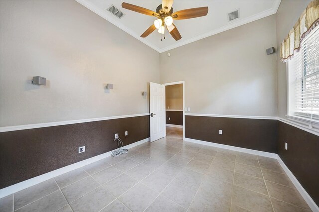 tiled spare room with ceiling fan, high vaulted ceiling, and crown molding