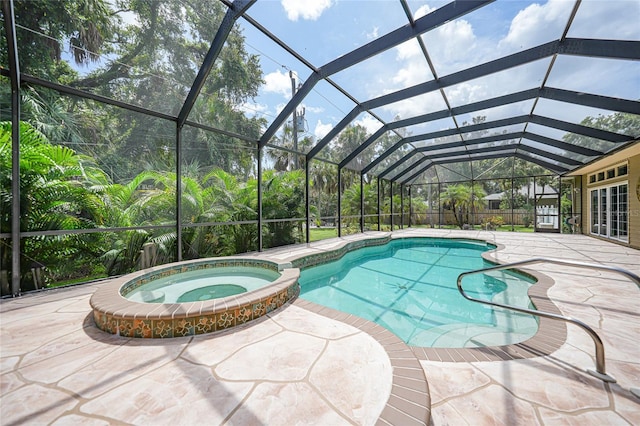 view of swimming pool with a patio area, glass enclosure, and a pool with connected hot tub