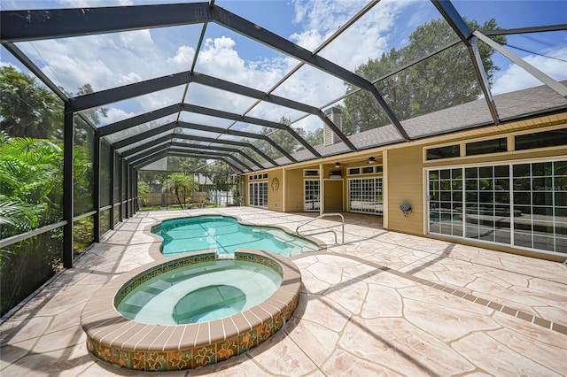 view of pool with a patio area, glass enclosure, a pool with connected hot tub, and ceiling fan