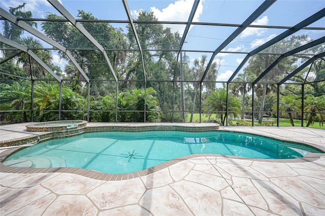 view of swimming pool featuring glass enclosure, a patio, and a pool with connected hot tub