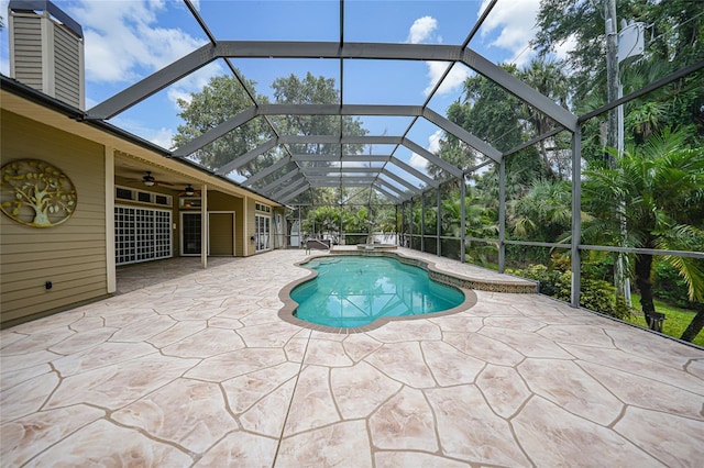 outdoor pool featuring a lanai, a patio area, and ceiling fan