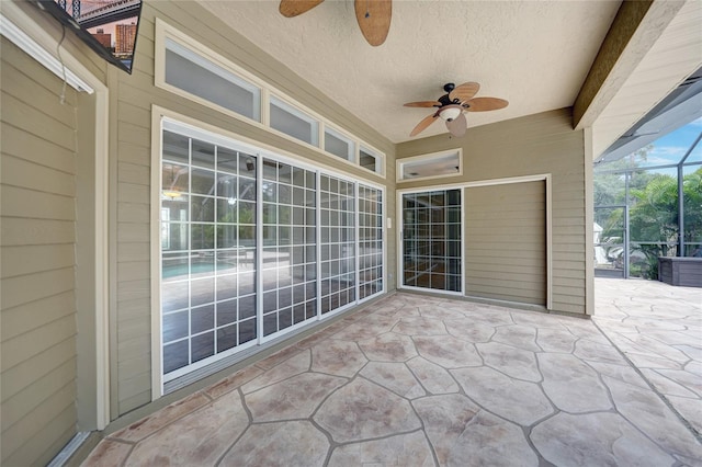 view of patio featuring glass enclosure and ceiling fan