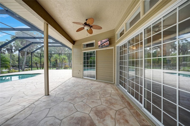 view of patio / terrace featuring glass enclosure, an outdoor pool, and a ceiling fan