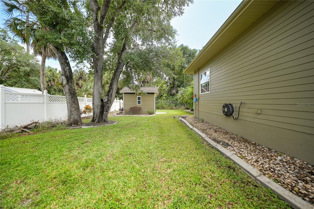 view of yard with an outbuilding and fence