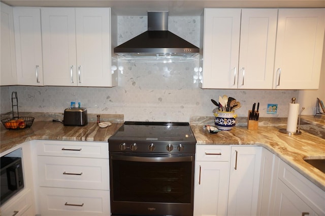 kitchen with backsplash, white cabinetry, wall chimney exhaust hood, and stainless steel range with electric cooktop