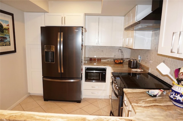 kitchen with light stone countertops, wall chimney exhaust hood, stainless steel refrigerator with ice dispenser, range, and white cabinetry