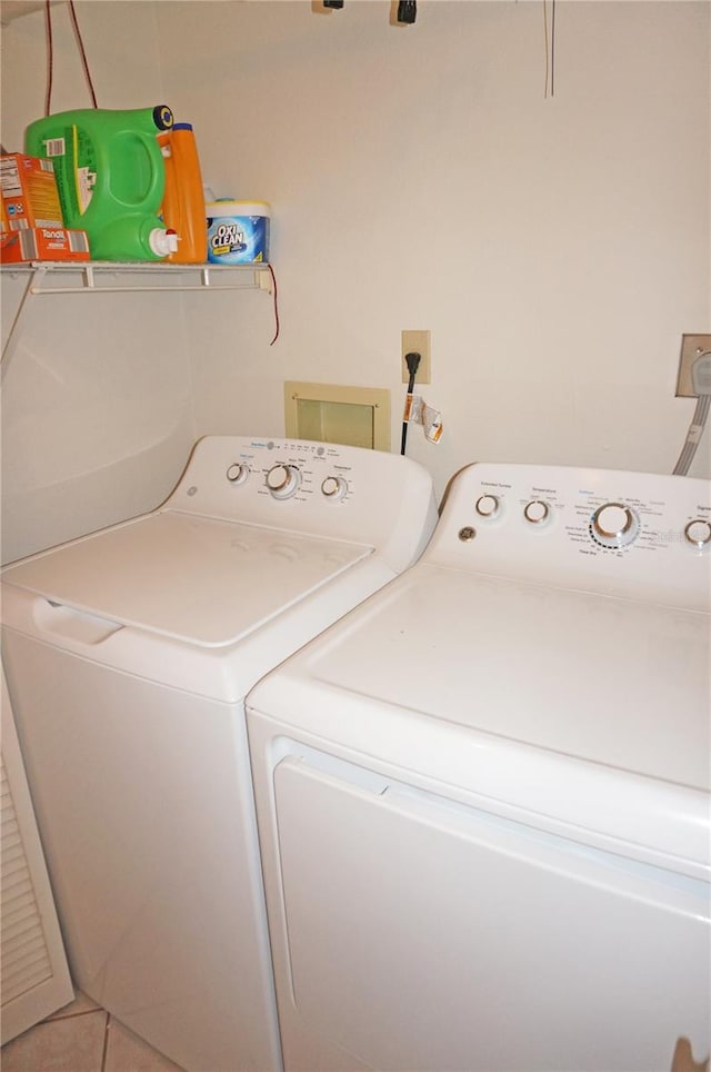 clothes washing area with washer and dryer and tile patterned flooring