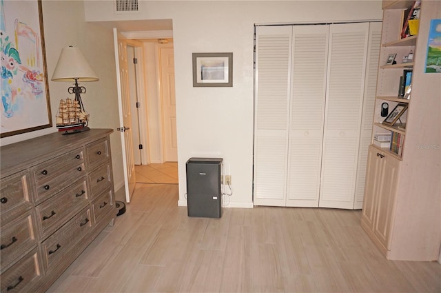 bedroom with light hardwood / wood-style flooring and a closet