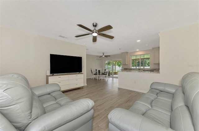 living room with recessed lighting, visible vents, light wood-style floors, ceiling fan, and baseboards