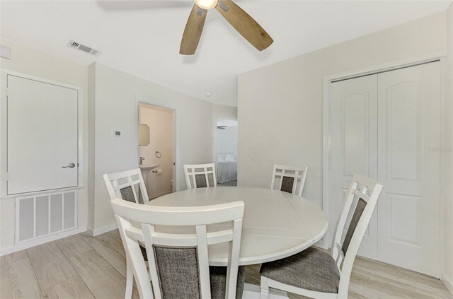 dining area featuring light wood-style floors, visible vents, and a ceiling fan