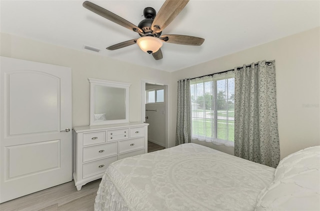 bedroom featuring light wood-style floors, ceiling fan, and visible vents