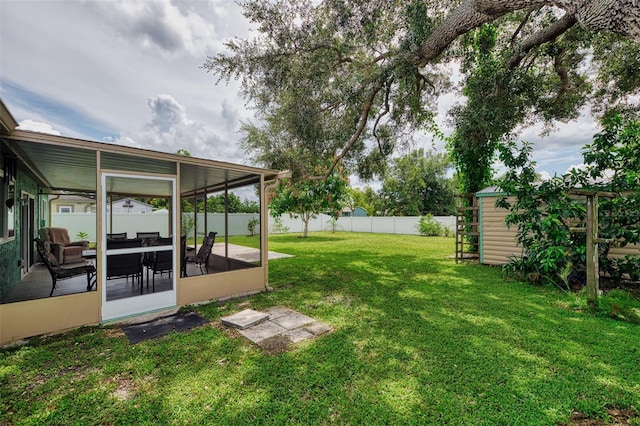 view of yard featuring a sunroom, a fenced backyard, a shed, and an outdoor structure