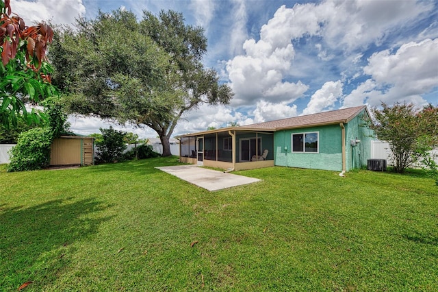 back of house featuring a sunroom, central AC, a patio, and a lawn