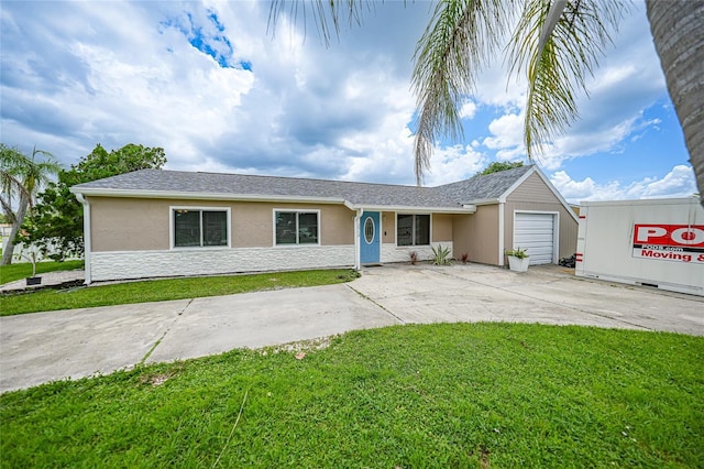 single story home featuring a garage, a front yard, driveway, and stucco siding