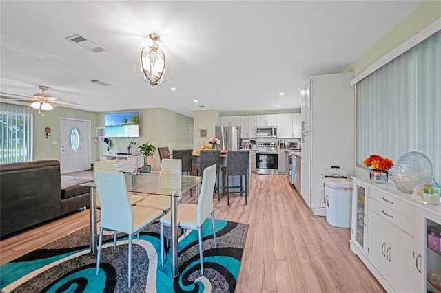 dining room with a notable chandelier, light wood finished floors, visible vents, and recessed lighting