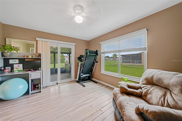 workout area with light wood-style floors and baseboards