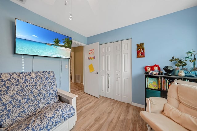 living area featuring light wood-type flooring, visible vents, and baseboards