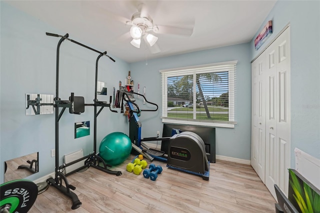 exercise area with a ceiling fan, baseboards, and wood finished floors