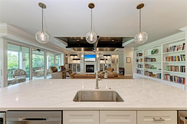 kitchen with light stone counters, open floor plan, white cabinets, and a fireplace