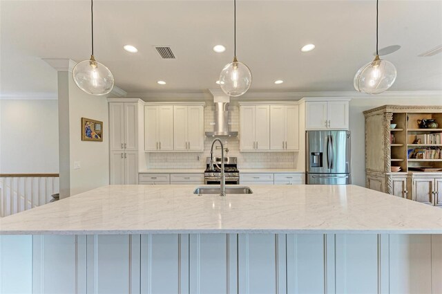 kitchen with wall chimney exhaust hood, appliances with stainless steel finishes, and decorative light fixtures