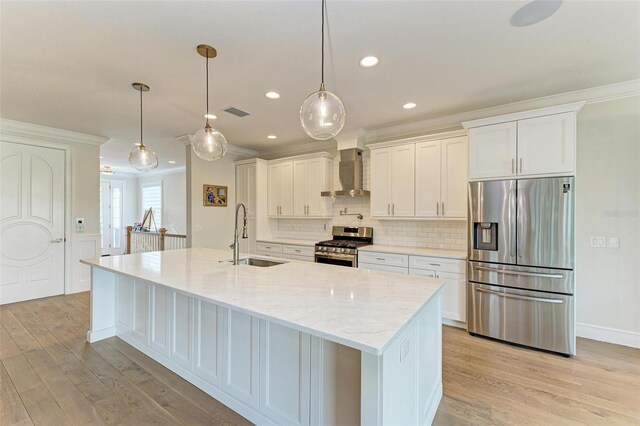 kitchen featuring wall chimney exhaust hood, appliances with stainless steel finishes, a sink, and white cabinetry