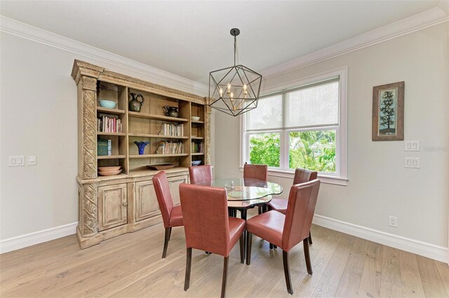 dining space with light wood-style floors, baseboards, ornamental molding, and a chandelier