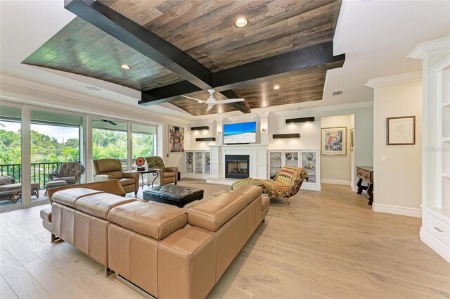 living room featuring light wood finished floors, visible vents, baseboards, a fireplace with raised hearth, and beam ceiling