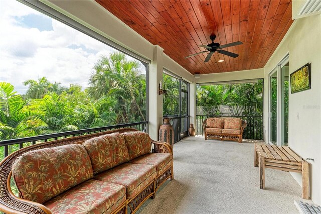 sunroom featuring wood ceiling and a ceiling fan