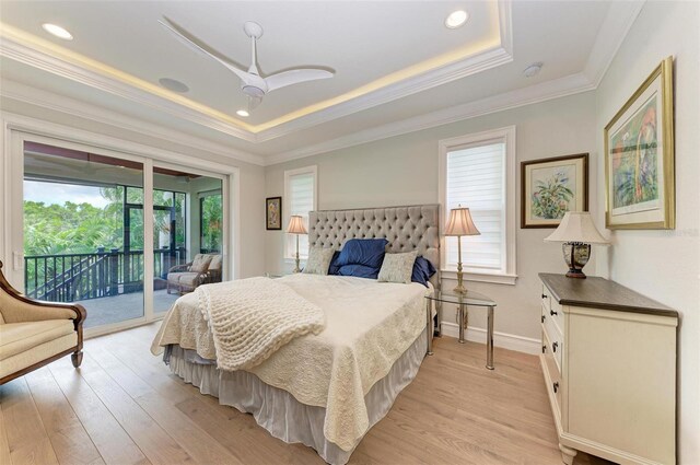 bedroom featuring ornamental molding, access to outside, a raised ceiling, and light wood-style flooring