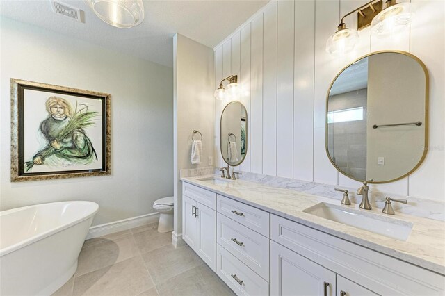 bathroom featuring a freestanding tub, visible vents, a sink, and toilet