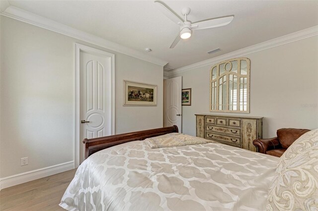 bedroom with crown molding, visible vents, light wood-style flooring, ceiling fan, and baseboards