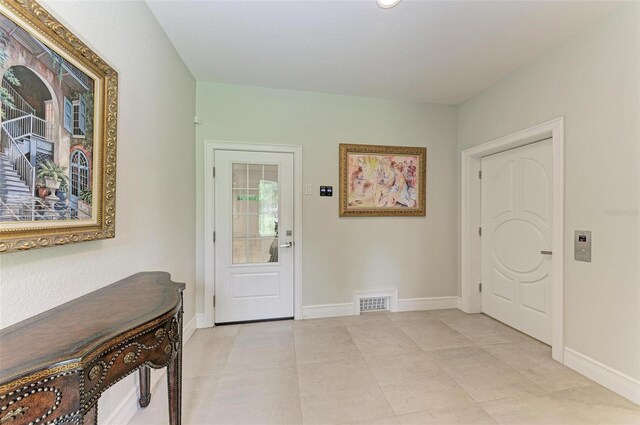 foyer with visible vents, baseboards, and light tile patterned flooring