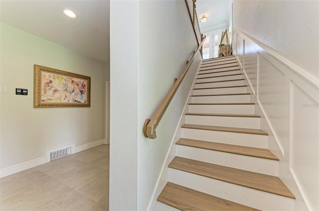 stairway featuring wainscoting, visible vents, a decorative wall, and recessed lighting