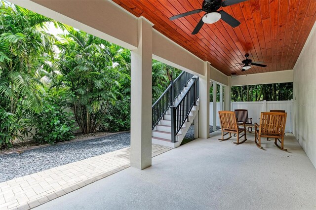 view of patio / terrace featuring a ceiling fan, fence, and stairway