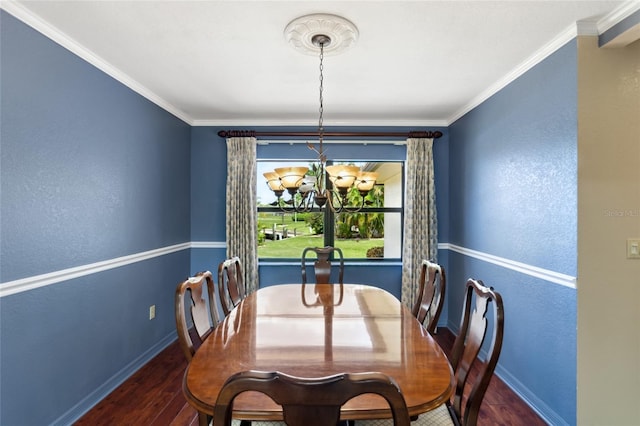 dining area with dark wood-type flooring, an inviting chandelier, and ornamental molding