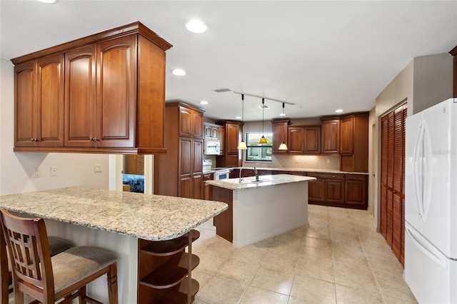 kitchen featuring a center island, kitchen peninsula, white appliances, hanging light fixtures, and a breakfast bar area