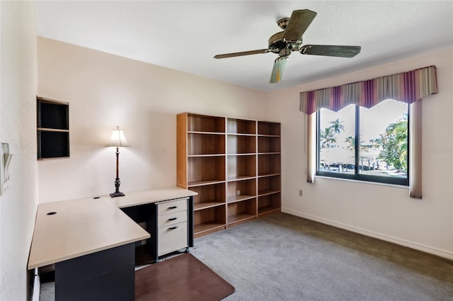 unfurnished office with ceiling fan and dark carpet