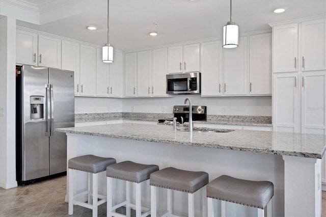 kitchen with an island with sink, stainless steel appliances, crown molding, and white cabinetry