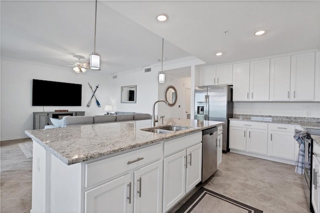 kitchen with ornamental molding, an island with sink, sink, and ceiling fan