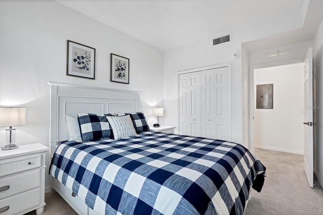 bedroom with electric panel, light colored carpet, and a closet