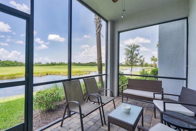 sunroom featuring a water view