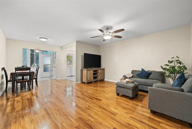 living room with light wood-type flooring and ceiling fan