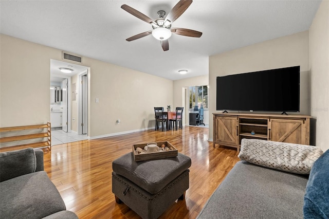 living room featuring ceiling fan and light hardwood / wood-style flooring