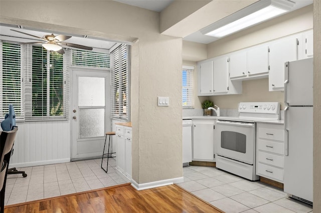 kitchen featuring light hardwood / wood-style flooring, ceiling fan, white appliances, and white cabinets