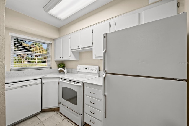 kitchen with white cabinets, white appliances, sink, and light tile patterned flooring