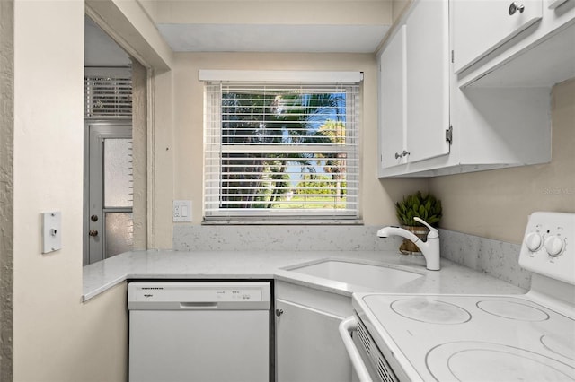 kitchen featuring white appliances, light stone countertops, white cabinetry, and sink