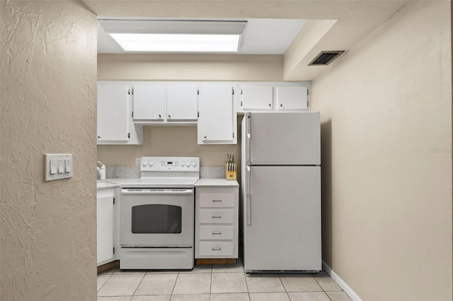 kitchen featuring light tile patterned floors, white appliances, and white cabinets