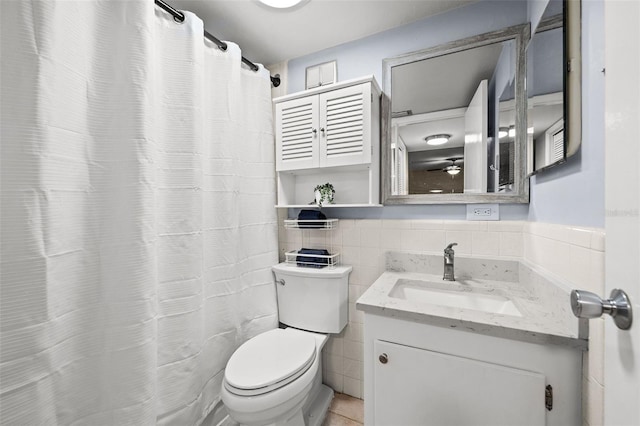 bathroom with toilet, tile patterned flooring, vanity, decorative backsplash, and tile walls